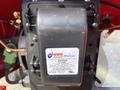 A close-up view of an electronic ignition transformer labeled 2270U with specifications for primary and secondary voltage connections on a pressure washer