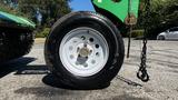 A close-up view of a white-spoked wheel from a 2017 Laymor SweepMaster 300 with a dark tire featuring red and white stripes along the rim