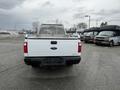 White 2010 Ford F-250 SD pickup truck viewed from the rear with a metal bed rack and the model name Super Duty visible on the tailgate