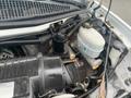 Engine compartment of a 2012 Chevrolet Express showcasing various mechanical components including the air intake system brake fluid reservoir and cables