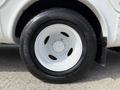 Close-up of a white wheel and tire from a 2010 Ford Econoline featuring a sleek design and bold tread pattern