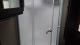 Shower stall with frosted glass doors and a handle in a 2021 Grand Design Recreational 311BHS