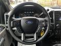 Steering wheel of a 2017 Ford F-150 with Ford logo and various controls visible at the sides