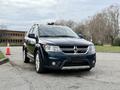 A blue 2013 Dodge Journey parked with a silver grille and chrome accents showcasing its sporty design and spacious body