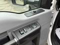 A close-up view of the driver's side door panel of a 2013 Ford F-550 featuring window control buttons and a textured handle