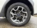 Close-up of a silver alloy wheel with a distinctive design on a 2016 Subaru Crosstrek featuring a black tire with visible tread patterns