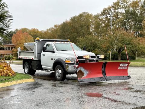 A 2012 Dodge Ram 5500 with a snow plow attached in front and a dump bed in the back designed for snow removal and hauling materials