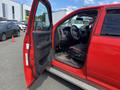 A red 2012 RAM 2500 truck with the driver's door open showing the interior features like the steering wheel and dashboard