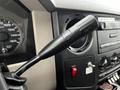 A close-up view of the gear shift lever inside a 2008 Ford F-450 SD with various controls and gauges visible in the background