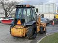 A 2005 Case 570 backhoe loader with large tires and a distinctive glass cab showing yellow and black colors