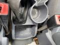 The image shows the interior cup holder area of a 2013 Ford Transit Connect including a gear shifter and two red seatbelt latches
