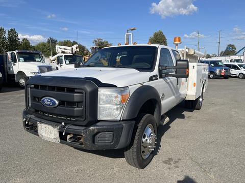 A 2015 Ford F-450 Super Duty truck in white with a black grille and a service body attached to the bed