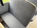 A gray upholstered seat in a vehicle with a solid structure and simple design
