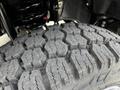 Close-up of a rugged tire tread of a 2024 Ford F-550 showcasing deep grooves and a hexagonal pattern for enhanced traction and durability