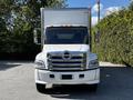 A white 2021 Hino 338 box truck is shown from the front featuring a prominent chrome grille and multiple headlights