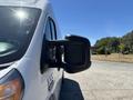 A white 2016 RAM Promaster van with a large side mirror visible in the foreground