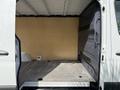 A 2021 Mercedes-Benz Sprinter van with an open side door showing an empty cargo area featuring a wooden panel and a flat floor