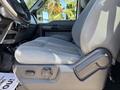A side view of the driver's seat in a 2016 Ford F-550 featuring gray upholstery and an adjustable lever on the side
