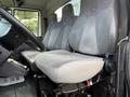 Interior view of a 2011 International WorkStar showing two gray upholstered seats with adjustable headrests and controls on the side of the driver's seat