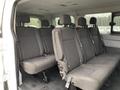 Interior of a 2017 Ford Transit showing two rows of upholstered seating with five seats in total and seatbelts visible