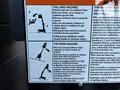 A safety warning sign detailing hazards associated with a 2000 JLG 12SP lift including falling and tip-over hazards with illustrations and instructions for safe operation