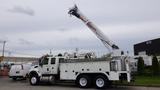 A white 2012 International 7400 utility truck with a raised boom crane attached on the back and storage compartments on the side