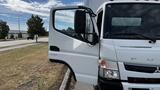 A 2018 Mitsubishi Fuso FE truck with its driver's side door open