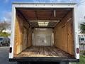 Empty interior of a 2021 Ford Econoline box truck featuring wooden walls and floor with a metal access door visible on the rear wall