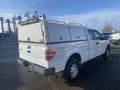 A 2013 Ford F-150 pickup truck with a white exterior and a fitted bed cover in the rear