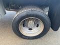 Close-up of a tire on a 2009 Ford F-450 SD showing detailed tread pattern and wheel rim with visible rust and dirt