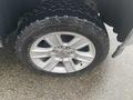 Close-up of a silver alloy wheel with a rugged tire from a 2015 GMC Sierra 1500 showing tread pattern and markings