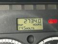 Display screen of a 2006 Freightliner M2 112 showing trip hours as 2734.0 and voltage at 14.5 volts with a red indicator light illuminated