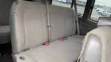 A rear bench seat in a 2017 Chevrolet Express Quigley 4x4 with gray upholstery and seat belts