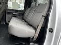 A 2017 Ford F-550 with a gray fabric bench seat in the rear passenger area showing seatbelts and a clean interior