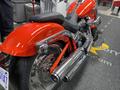 A red 2024 Harley Davidson Fat Boy motorcycle with chrome details and large rear tire visible from an angled view