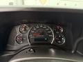 A close-up view of the instrument cluster in a 2021 Chevrolet Express displaying speedometer fuel gauge and various warning lights