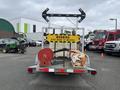 A 2011 Hightliner Aquacide Hot Water Weed Control Dual Flat Deck Trailer featuring a warning sign and two mounted hoses on the rear