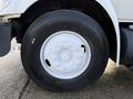Close-up of a large black tire mounted on a white wheel with multiple lug nuts on a 2010 International 4300 truck