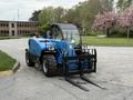 A blue 2020 Genie GTH-5519 telehandler with a front bucket and fork attachment parked on a gravel surface
