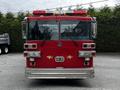 A red 1991 Sutphen Deluge fire truck with a chrome front bumper and multiple lights on top, featuring two sets of headlights and distinctive silver detailing