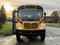 A 2013 International 4300 school bus with a yellow and black color scheme is positioned head-on showcasing its front features and large windshield