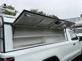 A 2022 GMC Sierra 1500 with the truck bed cover lifted open revealing empty storage space inside the bed