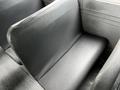 Interior view of a 2015 Spartan School Bus featuring dark gray vinyl seats arranged in a row with a textured surface