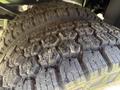 Close-up of the tread on two rugged truck tires showcasing deep grooves and a pronounced pattern designed for off-road traction