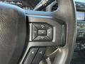 Steering wheel controls of a 2020 Ford F-550 featuring buttons for volume and media adjustment