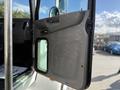 A 2015 Peterbilt 337 truck door open showing a gray interior with a large window and door handle