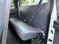 A gray vinyl bench seat in the rear of a 2001 Ford F-350 with seatbelts attached