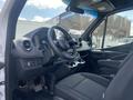 Interior view of a 2025 Mercedes-Benz Sprinter showing the driver's seat dashboard and steering wheel with modern controls and a spacious cabin design