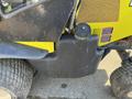 Close-up of the engine compartment of a yellow 2010 Kubota F3990 showing the engine cover and side panel with labels and a coolant reservoir