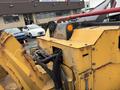 A yellow 2015 Vermeer Corporation BC1200XL wood chipper featuring hoses and control panels with visible rust on the surface
